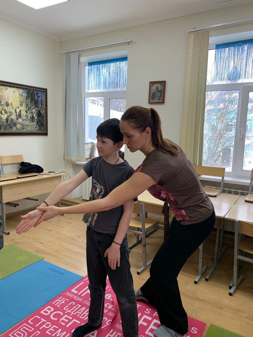 Педагог и ученик выполняют упражнение стоя